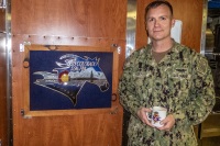 Commanding Offficer CDR Reed Koepp with the ship's crest